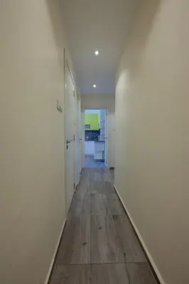 an empty hallway with white walls and wood floors at Julie Suite Top Center in Sofia