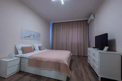 a white bedroom with a bed and a television at Julie Suite Top Center in Sofia