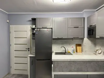 a kitchen with white cabinets and a stainless steel refrigerator at Nice new apartment in Sofia