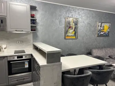 a kitchen with a counter and a table with chairs at Nice new apartment in Sofia