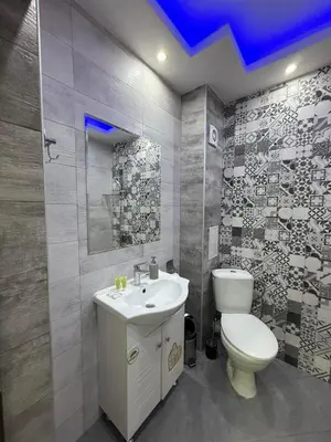 a bathroom with a white toilet and a sink at Апартаменти в сърцето на парка in Sandanski