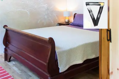 a bedroom with a bed with a wooden frame at Стаи за гости в Ритрийт Център 