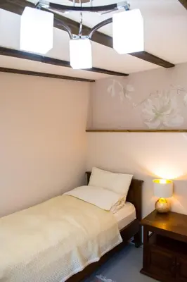 a bedroom with a bed and a table and lights at Стаи за гости в Ритрийт Център 