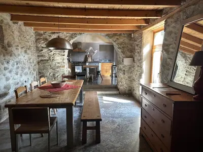 a kitchen and dining room with a wooden table and chairs at Подковите in Karlovo