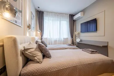 a hotel room with two beds and a window at Calm, Luxury Apartment, Premium Location at NDK! in Sofia