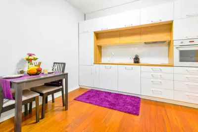a kitchen with white cabinets and a table and purple rug at Sofia's Best Kept Secret in Prime Location! in Sofia