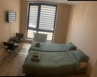 a bedroom with a bed and a table and a window at Brown Mur in Sofia