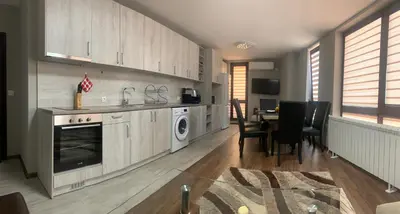 a kitchen with a washer and dryer and a table at Brown Mur in Sofia