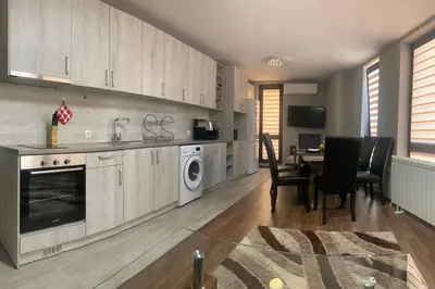 a kitchen with white cabinets and a table with chairs at Brown Mur in Sofia