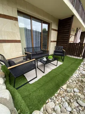 a patio with two chairs and a table on a lawn at Large One Bedroom with Terrace next to the Ski Lift in Bansko