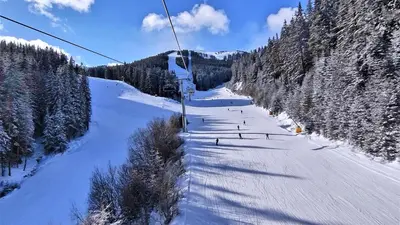 a ski lift going down a snow covered mountain at Large One Bedroom with Terrace next to the Ski Lift in Bansko