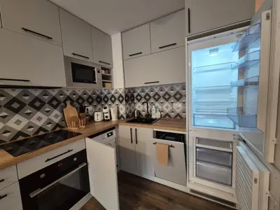 a kitchen with white cabinets and an empty refrigerator at Large One Bedroom with Terrace next to the Ski Lift in Bansko