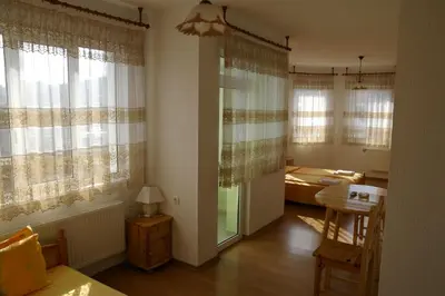 a living room with a table and a bedroom at Karadzhovy Guest House in Kalofer