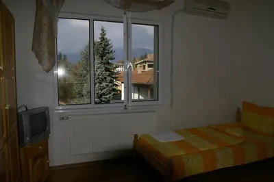 a bedroom with a window with a bed and a tv at Karadzhovy Guest House in Kalofer
