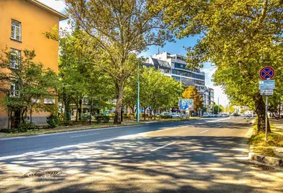 an empty street in a city with trees and buildings at Chic and Charming 2BD Flat in the Heart of Plovdiv by Flat Mаnager in Plovdiv