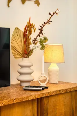 a table with a vase and a lamp on it at Chic and Charming 2BD Flat in the Heart of Plovdiv by Flat Mаnager in Plovdiv