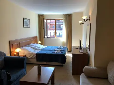 a hotel room with a bed and a couch at Simon1 studio, 2 min to gondola in Bansko