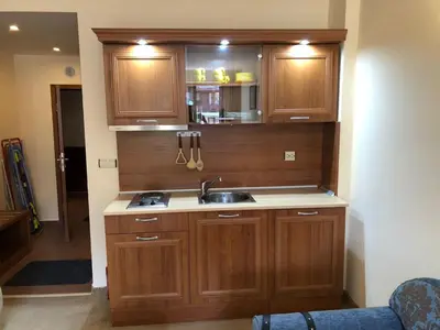 a kitchen with wooden cabinets and a sink at Simon1 studio, 2 min to gondola in Bansko