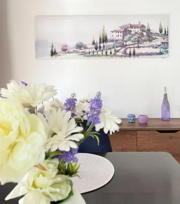 a vase of flowers on a table with a painting at Si apartments Free Parking in Sofia