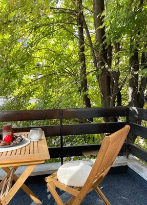 a table and chairs on a patio with trees at Si apartments Free Parking in Sofia