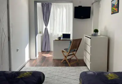 a room with a chair and a desk and a window at Si apartments Free Parking in Sofia