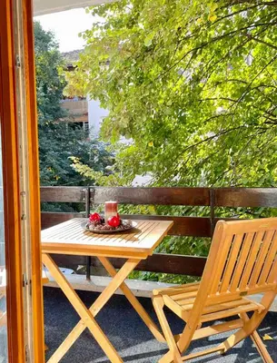 a wooden table and a chair on a patio at Si apartments Free Parking in Sofia