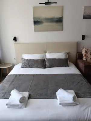 a bedroom with a large bed with towels on it at Monfort В in Bansko