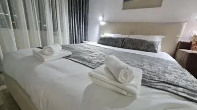 a bedroom with a large white bed with towels on it at Monfort В in Bansko
