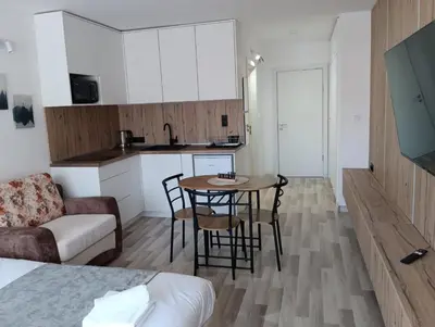 a living room with a table and a kitchen at Monfort В in Bansko