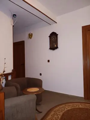 a living room with a couch and a clock on the wall at Хотел Марио in Melnik