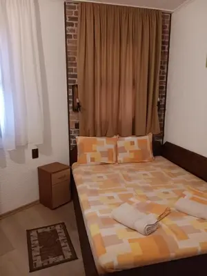 a bedroom with a large bed and a window at Хотел Марио in Melnik