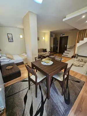 a living room with a wooden table and chairs at Apartment ZAX B7 in Terra Complex in Bansko