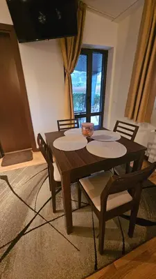 a wooden table and chairs in a living room at Apartment ZAX B7 in Terra Complex in Bansko