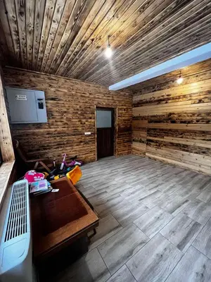 an empty room with wooden walls and a wooden floor at Райски кът “Еленова поляна” in Dobărsko