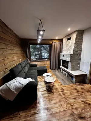 a living room with a couch and a fireplace at Райски кът “Еленова поляна” in Dobărsko