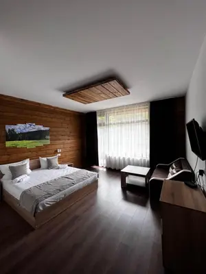 a bedroom with a large bed and a window at Райски кът “Еленова поляна” in Dobărsko