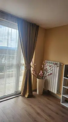 a vase with flowers in a room with a window at Budget overnight- Struma highway in Pernik