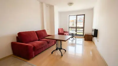 a living room with a red couch and a table at Mountain Paradise 4 - 1 Bedroom - Gondola, 100m away - Washer in Bansko