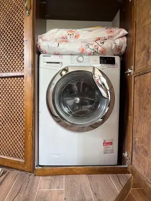 a washer and dryer in a wooden cabinet at River's house, free parking! in Sofia