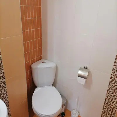a bathroom with a toilet and a toilet paper dispenser at M Art Apart in Sofia