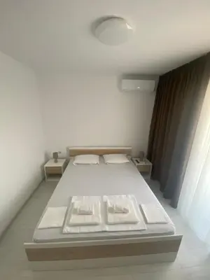 a bedroom with a white bed in a room at Апартамент Узунови in Sandanski