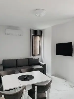a living room with a couch and a table and chairs at Апартамент Узунови in Sandanski
