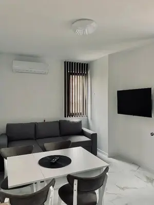 a living room with a couch and a table and chairs at Апартамент Узунови in Sandanski