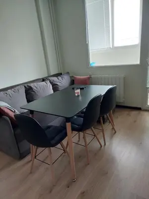 a table and chairs in a living room with a couch at Nova #7 in Sofia