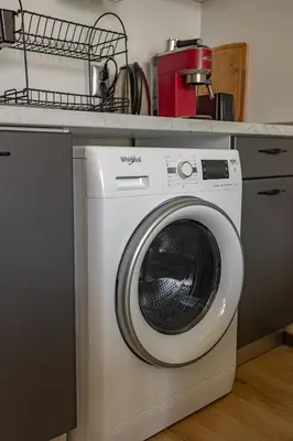a washing machine sitting under a counter in a kitchen at Nova #7 in Sofia