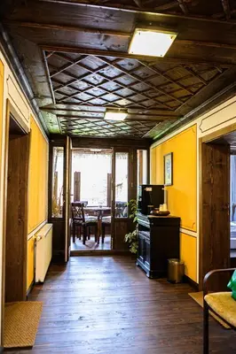 a living room with a wooden floor and yellow walls at Къща ЕТНО in Koprivshtitsa