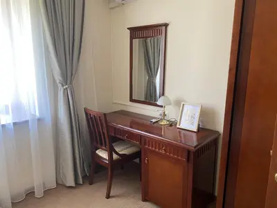 a desk with a mirror and a chair in a room at Next to the Ski Lift Downtown Bansko in Bansko