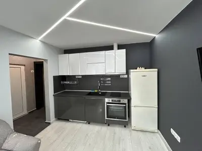 a kitchen with white cabinets and a refrigerator at Paradise M Apartments in Plovdiv