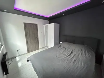 a bedroom with a bed with a purple light at Paradise M Apartments in Plovdiv