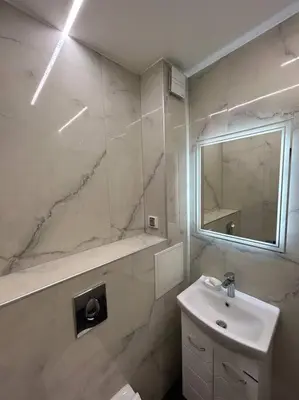 a white bathroom with a sink and a mirror at Paradise M Apartments in Plovdiv